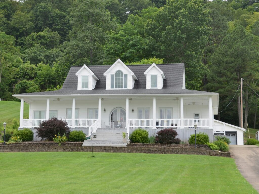 A white house that sits atop of manicured lawn