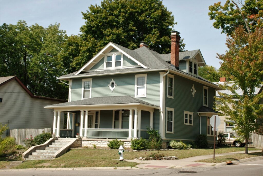 white and gray wooden house near green trees during daytime